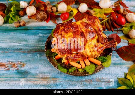 Thanksgiving day dinner table setting with whole roasted chicken on plate Stock Photo