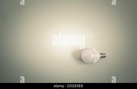 Electric energy-saving lamp on a light background. Stock Photo