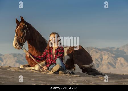 A Lovely Brunette Model Walks Her Horse Through The Desert On A Summers 