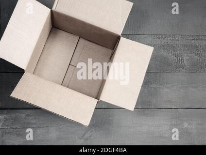 Cardboard box for postal items on a wooden background. Stock Photo