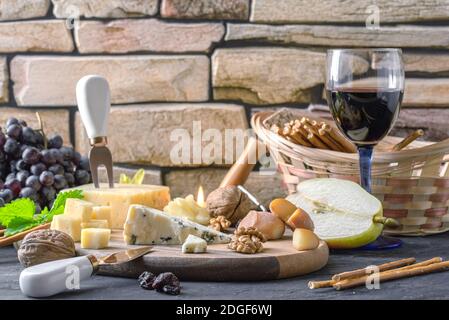 Still life with different varieties of cheese on wooden plate Stock Photo