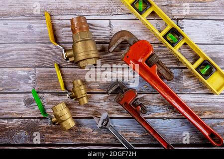 Monkey wrench brass plumbing fittings and level tape on construction concept. Stock Photo