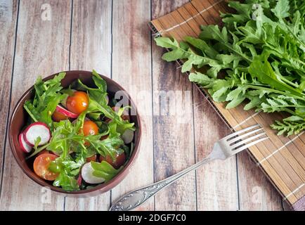 Salad of fresh vegetables and herbs on the table. Stock Photo