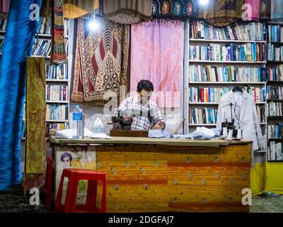 PALOLEM, GOA, INDIA - MARCH 19, 2019: Indian tailor at work late at night in Palolem, Goa, India Stock Photo