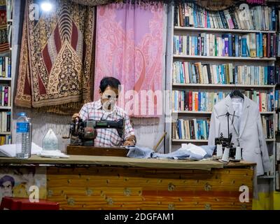 PALOLEM, GOA, INDIA - MARCH 19, 2019: Indian tailor at work late at night in Palolem, Goa, India Stock Photo