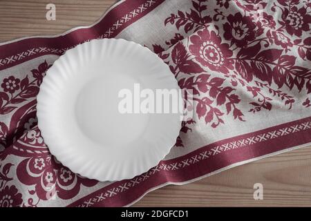 A white empty plate on a linen napkin Stock Photo