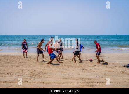 PALOLEM, GOA, INDIA - MARCH 19, 2018: Teenagers playing football on a sandy beach in Palolem, Goa, India Stock Photo