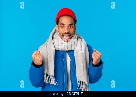 Yeah we can do it. Encouraged and motivated good-looking cheerful african american man in padded jacket, scarf winter beanie, cl Stock Photo