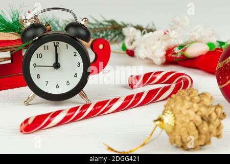 santa claus sleigh, alarm clock, santa claus staff, golden christmas tree cone and boxes with gifts on a white wood background with gold veins Stock Photo