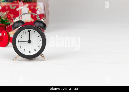 sleigh of santa claus, boxes with gifts and alarm clock on white wood background Stock Photo