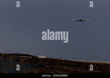 Airliner coming in to land under heavy rain clouds. Stock Photo
