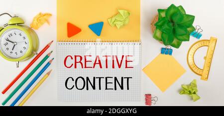 Business concept. Text CREATIVE CONTENT. Inspirational quotes on notebook and office supplies Stock Photo