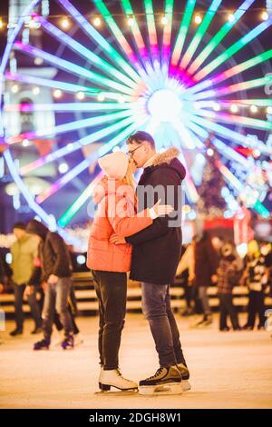 Couple hugging in Saint Valentine's Day. Young romantic pair having fun outdoors in winter. St. Valentines Day at city ice rink. Stock Photo