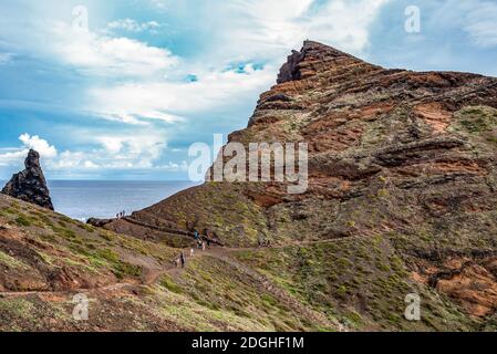 View of man hiking on rocky cliff clear water of Atlantic Ocean at Ponta de Sao Lourenco, the island of Madeira, Portugal Stock Photo