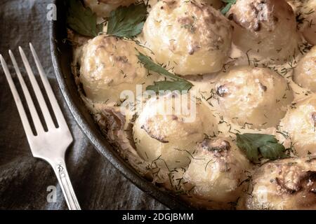 Young potatoes with cottage cheese are baked in the oven. Stock Photo