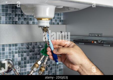 the plumber is cleaning the siphon of the washbasin in the bathroom. pipe blockage Stock Photo
