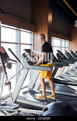 Man setting the control panel on the treadmill Stock Photo