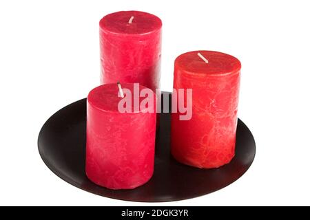 Three red decorative candles on a black plate Stock Photo