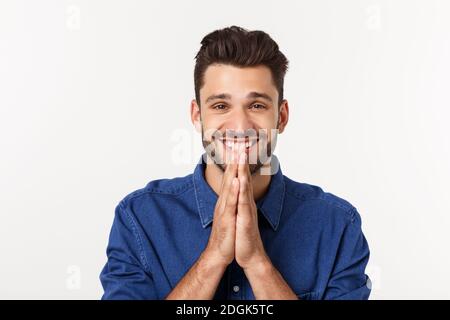 Happy Bearded man in shirt which showing pray gesture and looking up. Isolated gray background. Stock Photo
