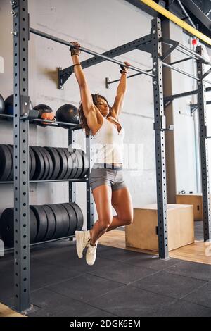 Sporty young woman doing the dead hang Stock Photo