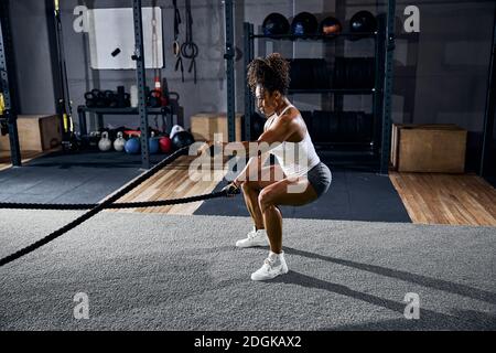 Athlete using the battle ropes during the training session Stock Photo