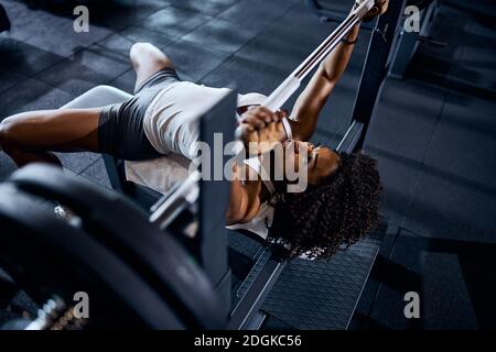 Serene strong sportswoman lifting the loaded barbell Stock Photo
