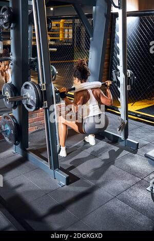 Fitness coach performing the barbell back squats Stock Photo