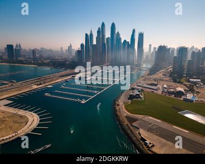 Dubai Marina skyscrapers and JBR beacg with luxury buildings and resorts in one of the United Arab Emirates travel spots and resorts in Dubai aerial v