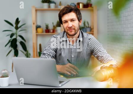 Smiling man photographer or retoucher working from home Stock Photo