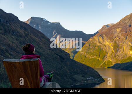 Female tourist enjoying the view over the famous Norwegian Geiranger fjord.  Stock Photo