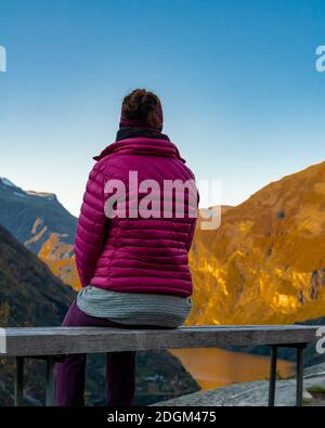 Female tourist enjoying the view over the famous Norwegian Geiranger fjord.  Stock Photo
