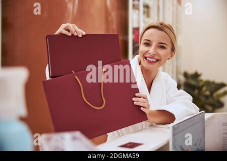 Merry lady holding a leather photo album in her hands Stock Photo