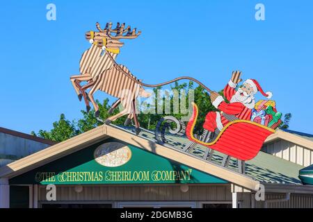 A corrugated iron sculpture of Santa and his reindeer on the roof of 'The Christmas Heirloom Company' in Tirau, New Zealand Stock Photo