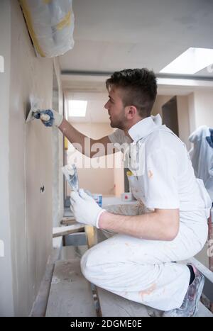 Construction worker plastering on gypsum walls Stock Photo
