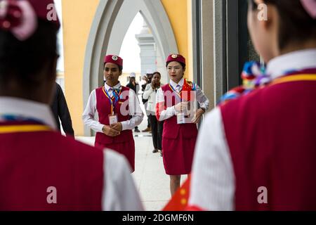 --FILE--African and Chinese railway attendants wearing standard uniforms of China's high-speed railway attendants wait for guests before a ribbon-cutt Stock Photo