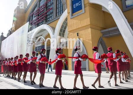 --FILE--African railway attendants wearing standard uniforms of China's high-speed railway attendants wait for guests before a ribbon-cutting ceremony Stock Photo