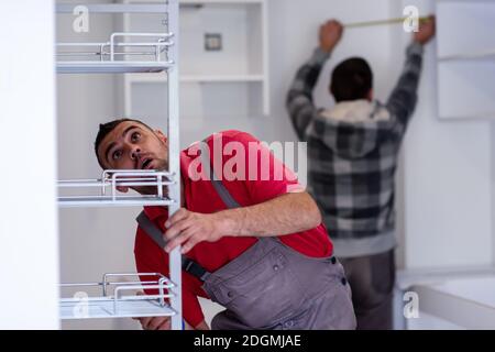 Workers installing a new kitchen Stock Photo