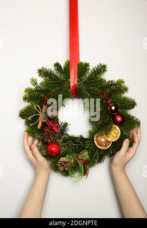 Beautiful Christmas wreath in woman hands. Festive interior decor. Stock Photo