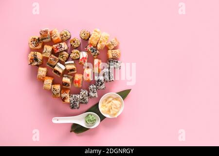 Sushi set in plate as heart served ginger, wasabi on pink