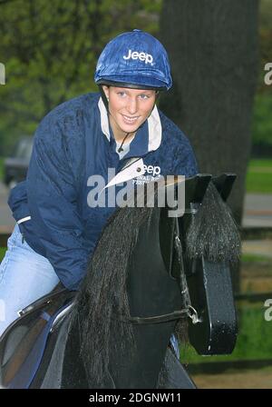 Zara Phillips and a mechanical horse that will give inner city children the chance to feel what its like to ride a horse in Hyde Park In London. Half Length. riding hat. funny  Stock Photo