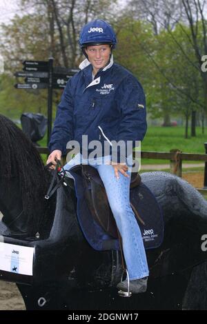 Zara Phillips and a mechanical horse that will give inner city children the chance to feel what its like to ride a horse in Hyde Park In London. Full Length. riding hat.  Stock Photo