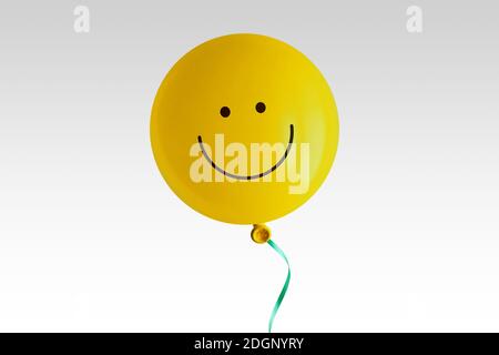 Yellow balloon with smile on white background - Concept of optimism and positive thinking Stock Photo