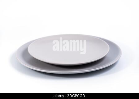 Grey Dish set - Large and small plates isolated on white background side view, selective focus Stock Photo