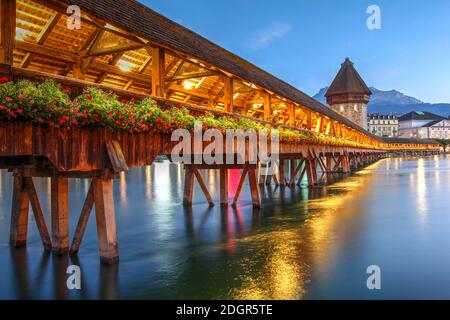 Perspective view of the picturesque Chapel Bridge over the Reuss River in Lucerne, one of the most quitesential symbols of Switzerland. Behind Mount P Stock Photo