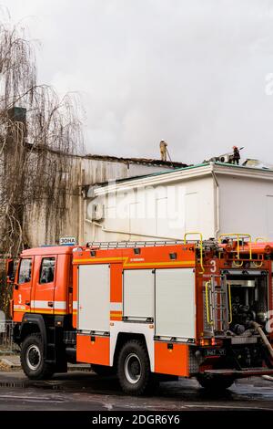 Poltava, Ukraine - 2020 December, historical building in fire with fireman standing  Stock Photo