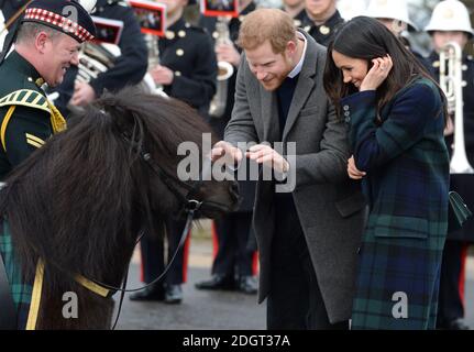 Prince Harry and Meghan Markle meet Pony Major Mark Wilkinson and regimental mascot Cruachan IV during a walkabout on the esplanade at Edinburgh Castle, during their visit to Scotland. Photo credit should read: Doug Peters/EMPICS Entertainment Stock Photo