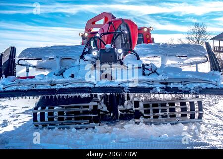 Snow grooming machine parked on top of ski mountain Stock Photo
