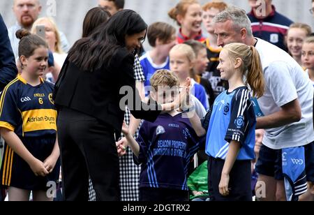 The Duchess of Sussex greets a young girl taking part in a Gaelic games demonstration during a visit to Croke Park on the second day of their visit to Dublin, Ireland. Photo credit should read: Doug Peters/EMPICS Stock Photo