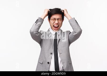 Depression, people and emotion concept. Waist-up portrait of tensed and stressed-out asian young man in formal suit, tie, pull h Stock Photo