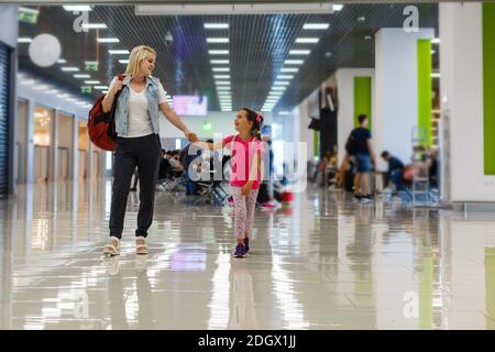 happy mother and daughter playing a game at airport before boarding Stock Photo